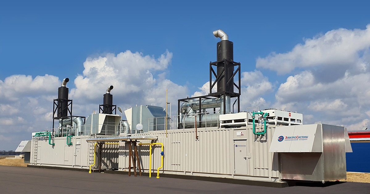 Three MWM Container CHP Plants at Voronezhskiy Champignon greenhouse and food production facility in Russia, under a sunny sky with white clouds.