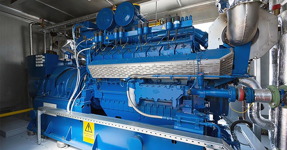 Interior of Biplast facility in Russia with one of two MWM TCG 2016 V16 gensets in Signature Blue. The full engine is visible in a narrow metal room with multiple pipes and connections attached.