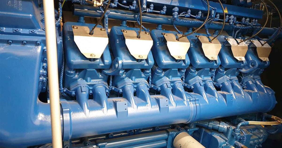 Side view of a single MWM TCG 2020 V12 engine in Signature Blue at Clinico Medical Sp. z o.o., Poland, filling most of the frame. Two engines are installed on site.
