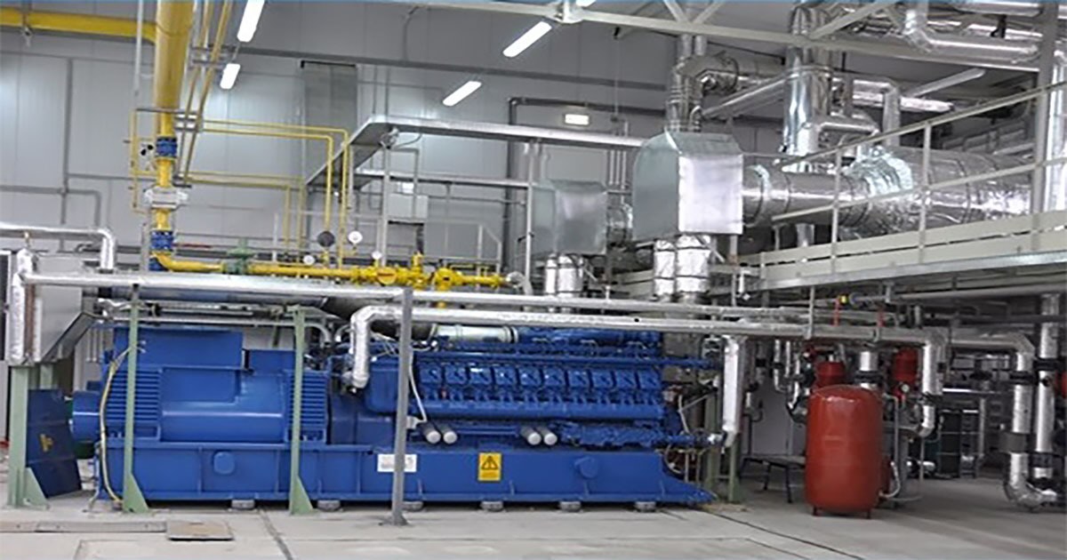 One of five MWM TCG 2020 V20 gas engines in signature blue supplying power and heat to Povolzhye Trade Center, Saratov, Russia; located inside an industrial hall, surrounded by pipes and equipment, with the MWM logo partially visible behind a pillar.